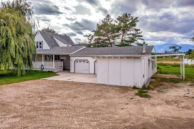 view of front of house featuring a garage, a front yard, and a porch