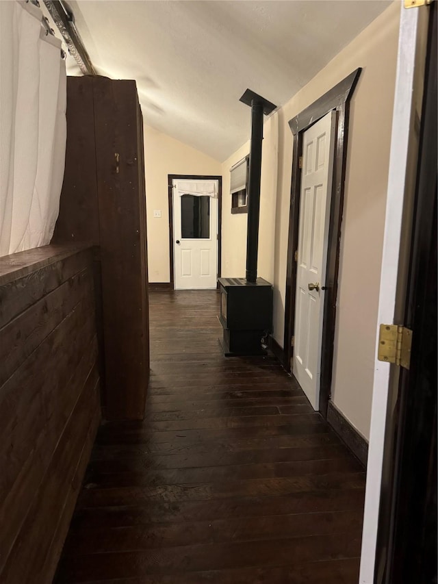 corridor with dark hardwood / wood-style flooring and vaulted ceiling