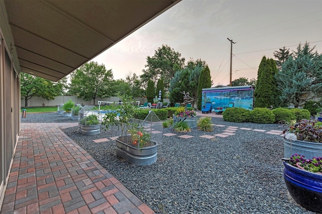 yard at dusk with a patio and fence