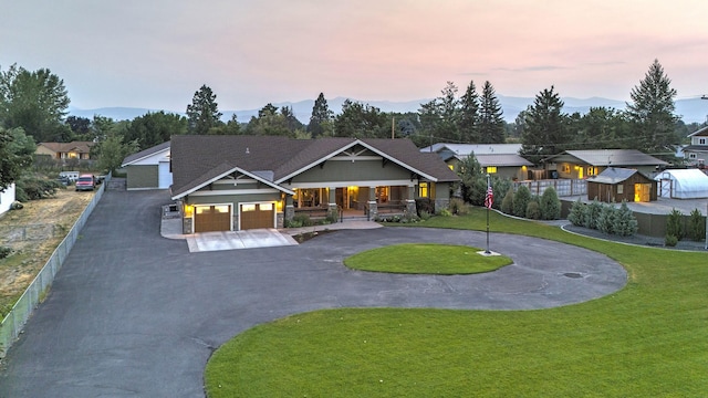 view of front of property with a yard, a porch, curved driveway, and a residential view