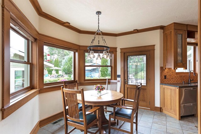 dining space with ornamental molding, a wealth of natural light, and visible vents