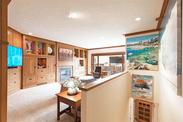 living area with carpet floors, built in shelves, recessed lighting, a glass covered fireplace, and a textured ceiling