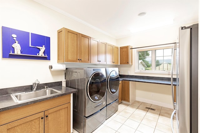 washroom with washing machine and clothes dryer, cabinet space, ornamental molding, light tile patterned flooring, and a sink