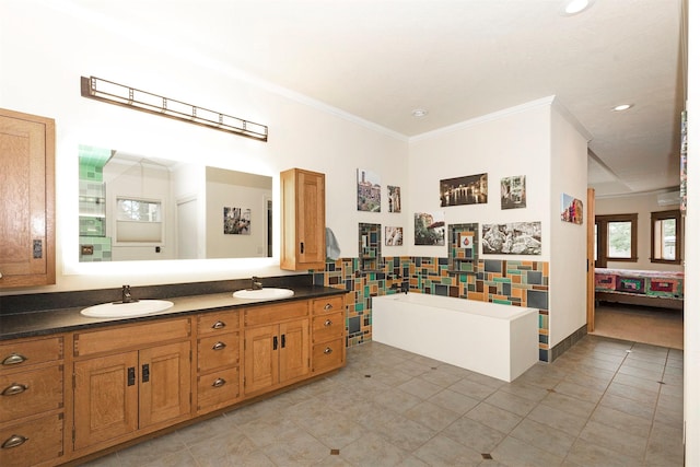 ensuite bathroom featuring double vanity, crown molding, tile walls, and a sink