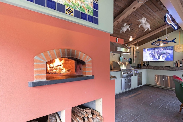 interior space featuring a grill, a fireplace, and exterior kitchen