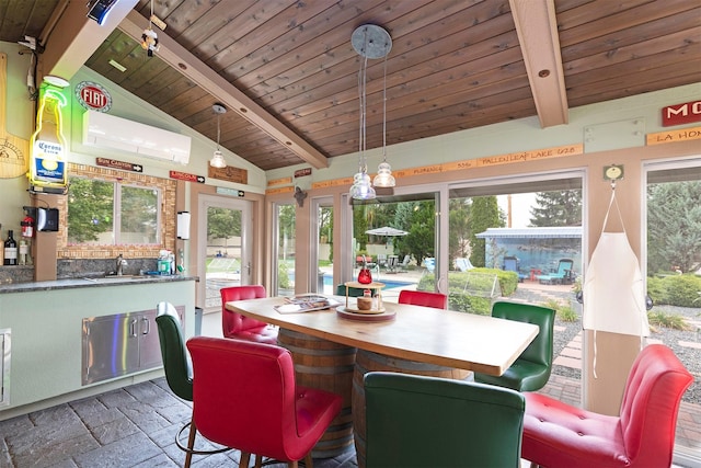 dining area featuring lofted ceiling with beams, wood ceiling, and stone tile flooring