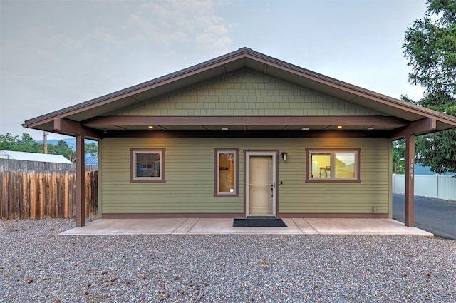 view of front of home with a patio, fence, and driveway