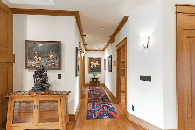 corridor with crown molding, baseboards, and wood finished floors