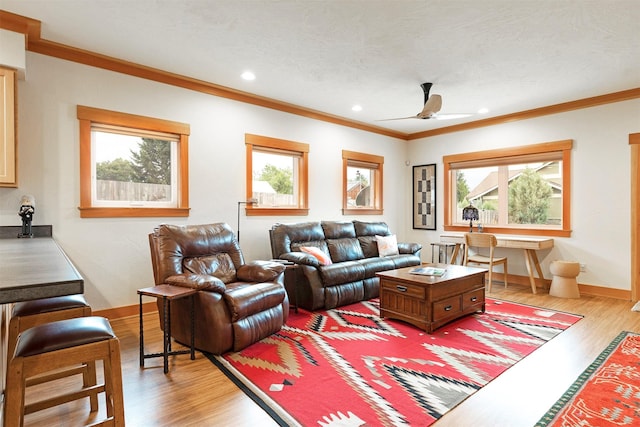 living room featuring recessed lighting, a ceiling fan, baseboards, ornamental molding, and light wood finished floors