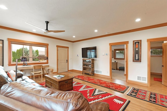 living room with visible vents, crown molding, and wood finished floors