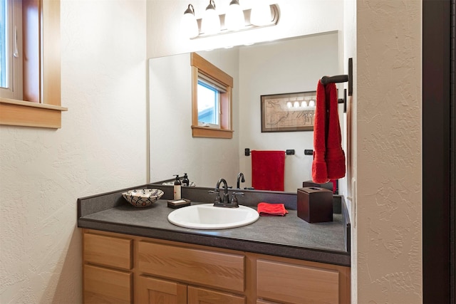 bathroom featuring a textured wall and vanity