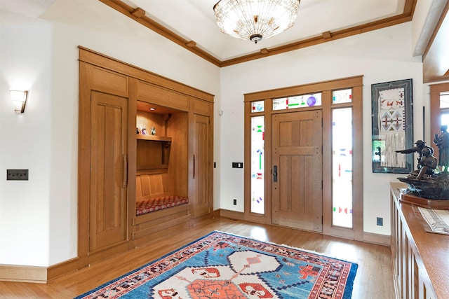 entryway featuring ornamental molding, light wood finished floors, and baseboards