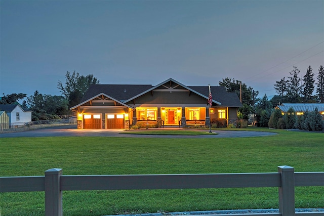 craftsman inspired home featuring an attached garage, driveway, a front lawn, and fence