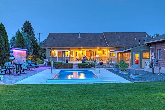 back of house featuring a patio area, an outdoor pool, and a lawn