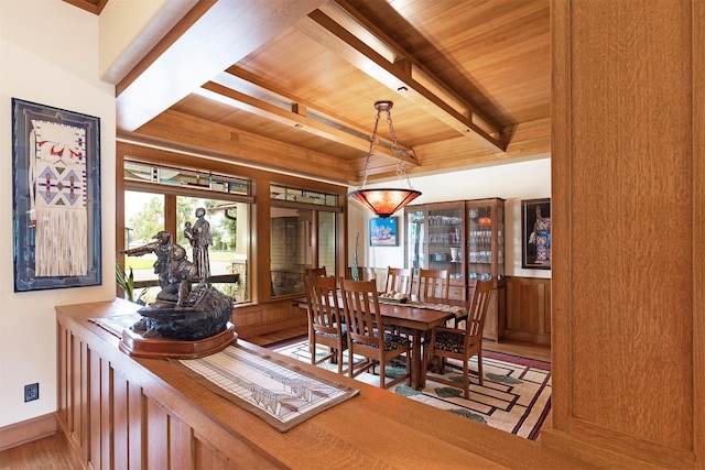 dining room with light wood-type flooring, wooden ceiling, and beam ceiling