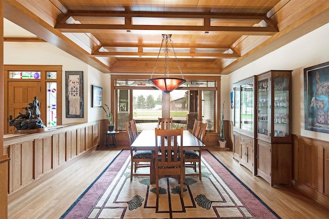 dining room featuring wood ceiling, light wood-type flooring, wainscoting, and a wealth of natural light