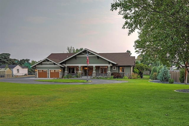 craftsman inspired home featuring aphalt driveway, a front yard, covered porch, and fence