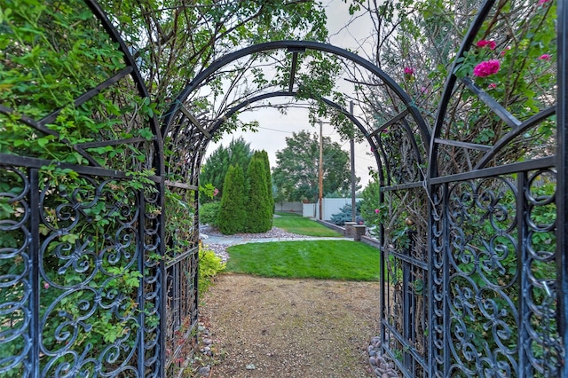 view of gate featuring fence and a lawn