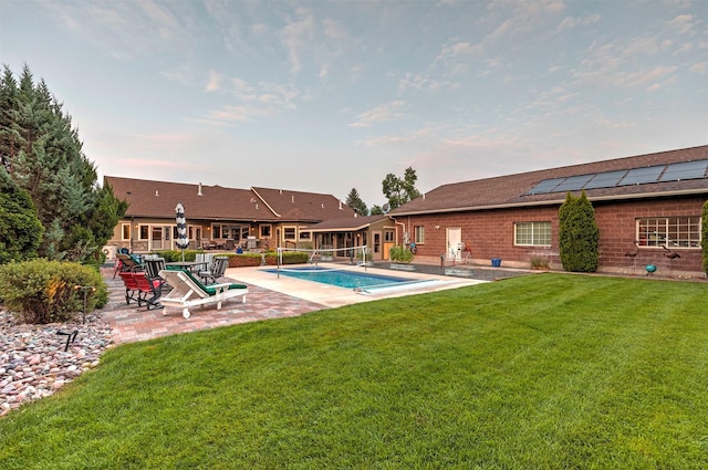 outdoor pool with a yard and a patio