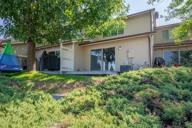 rear view of house featuring central air condition unit