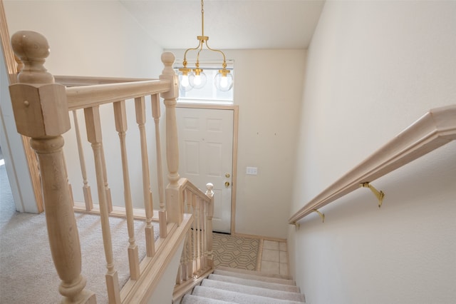 stairway with carpet and a chandelier