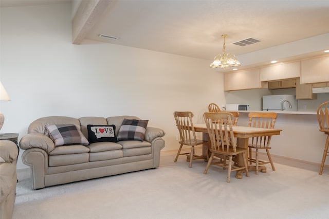 carpeted dining room featuring sink and a chandelier