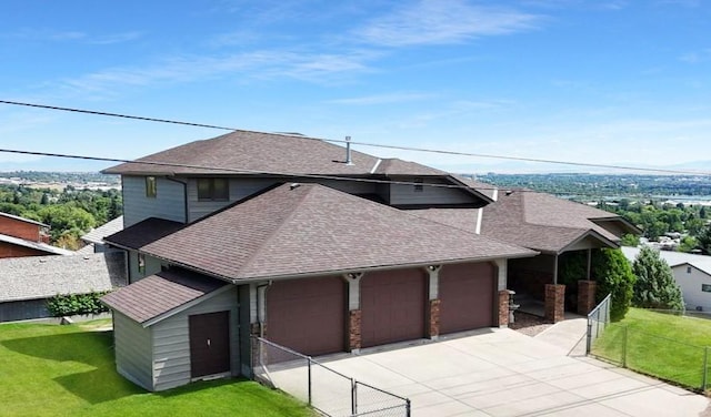 view of front of home with a garage, a shingled roof, concrete driveway, fence, and a front yard