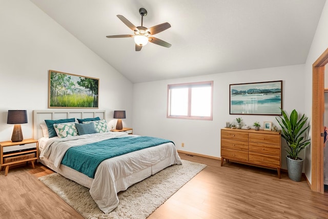 bedroom with ceiling fan, light wood-style flooring, and vaulted ceiling