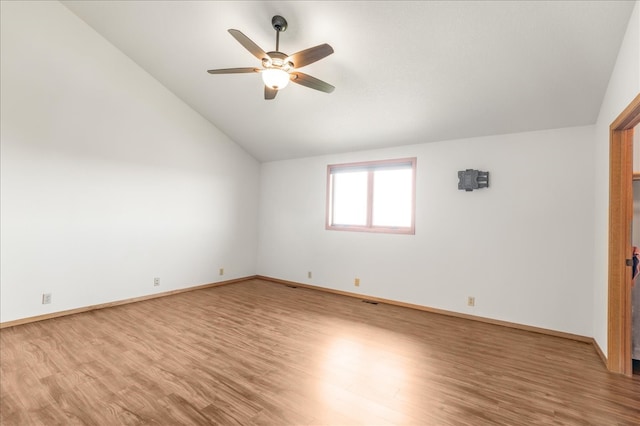 unfurnished room featuring lofted ceiling, wood finished floors, a ceiling fan, and baseboards