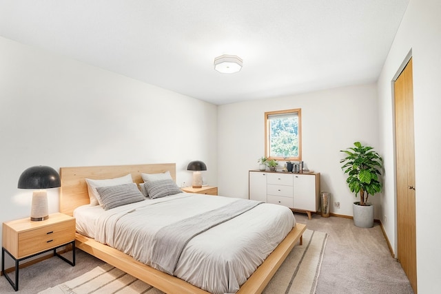 bedroom featuring light carpet and baseboards