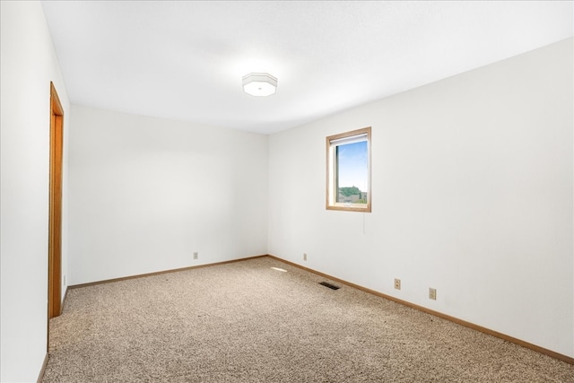 carpeted empty room featuring visible vents and baseboards