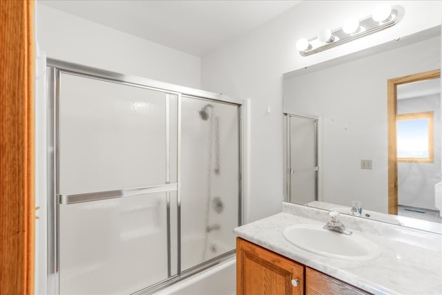 bathroom featuring shower / bath combination with glass door and vanity