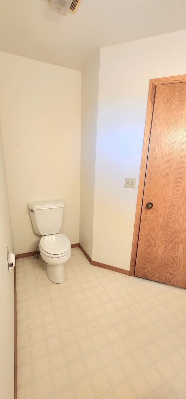 bathroom featuring visible vents, toilet, baseboards, and tile patterned floors