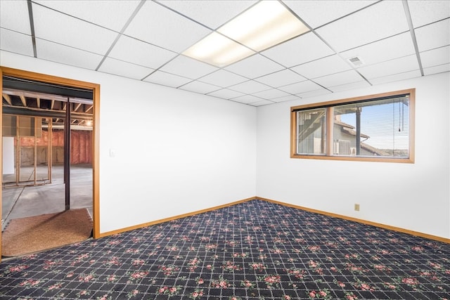 basement featuring carpet flooring, a paneled ceiling, and baseboards