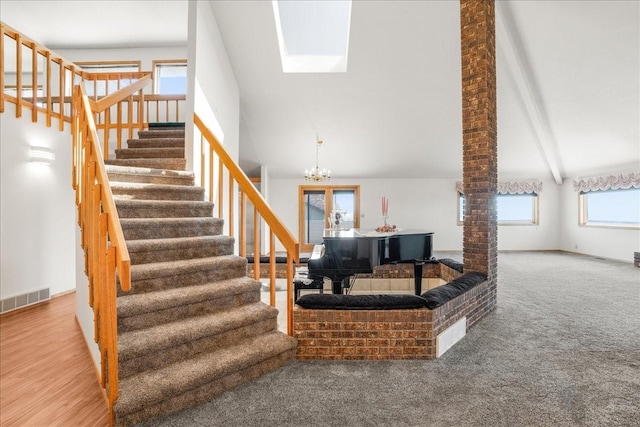 stairs with visible vents, beamed ceiling, an inviting chandelier, carpet, and high vaulted ceiling