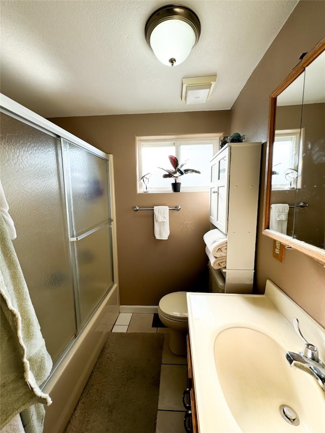 full bath with toilet, enclosed tub / shower combo, a textured ceiling, tile patterned flooring, and baseboards