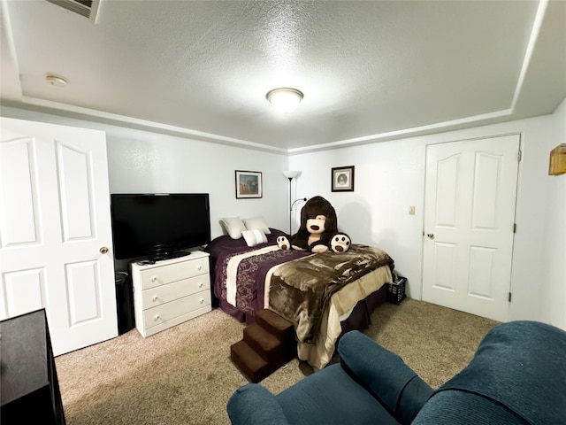 carpeted bedroom with visible vents and a textured ceiling