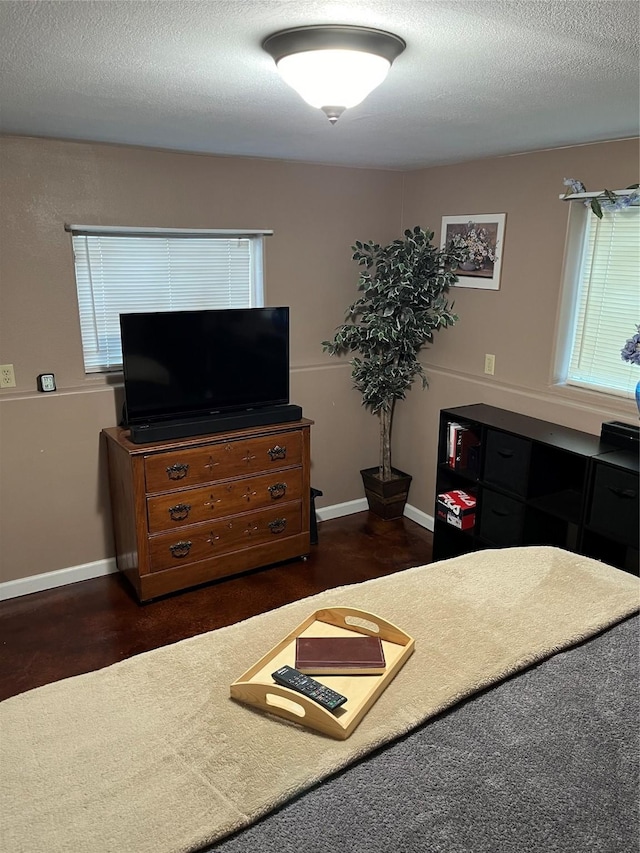 bedroom featuring dark wood-style floors, a textured ceiling, and baseboards