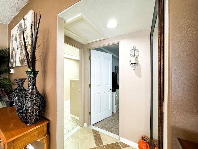 hallway featuring tile patterned floors, carpet flooring, and baseboards