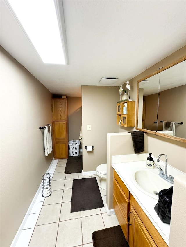 bathroom with tile patterned floors, baseboards, toilet, and vanity