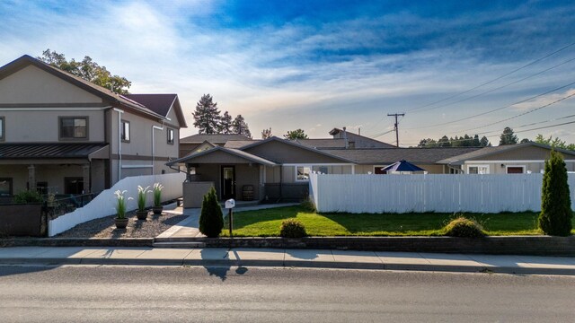 view of front facade featuring a front lawn and a fenced front yard