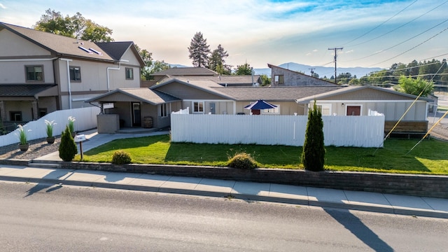 view of front of house with a fenced front yard and a front lawn