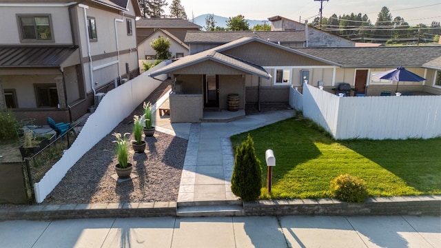 view of front of house with a standing seam roof, a front lawn, and fence private yard