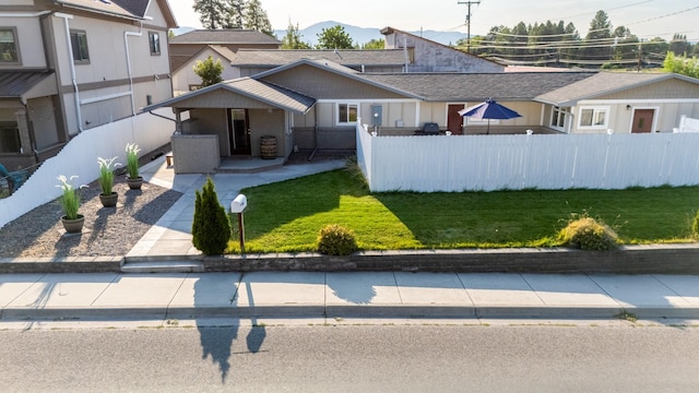 view of front of home with a front yard and fence