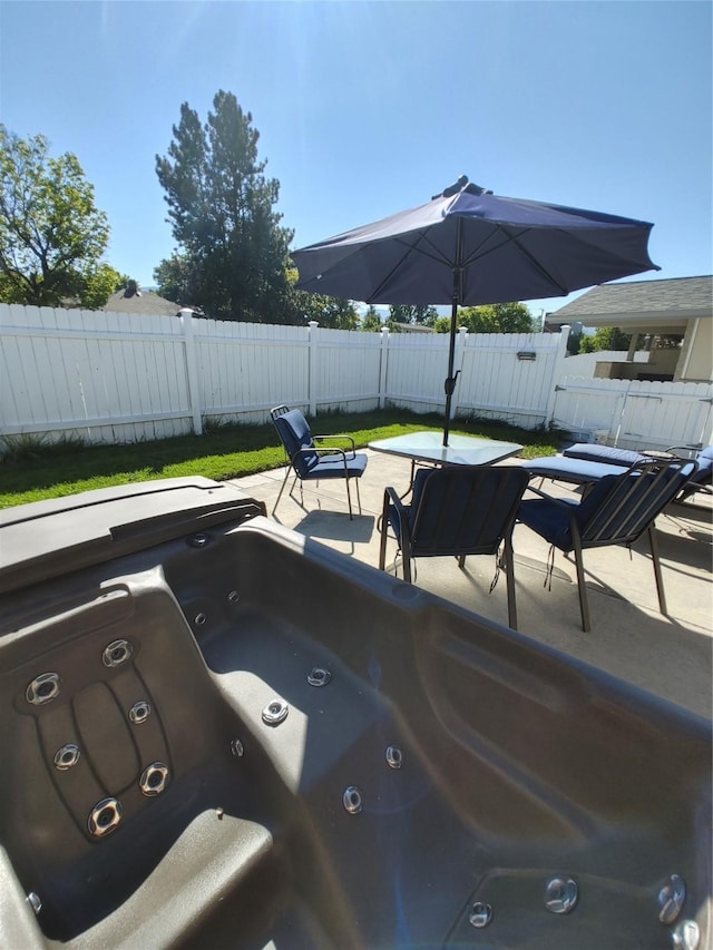 exterior space featuring a patio, a fenced backyard, and a hot tub