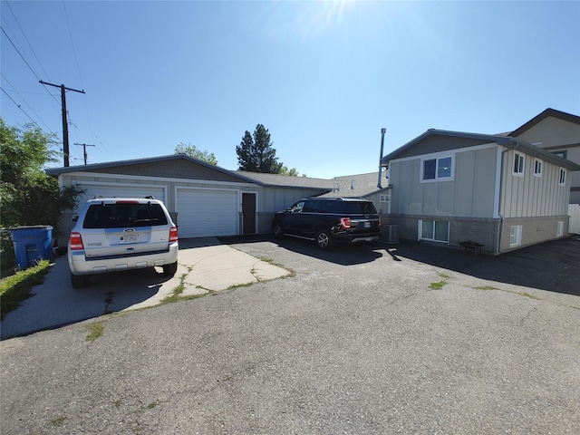 view of front of house with central air condition unit and a garage