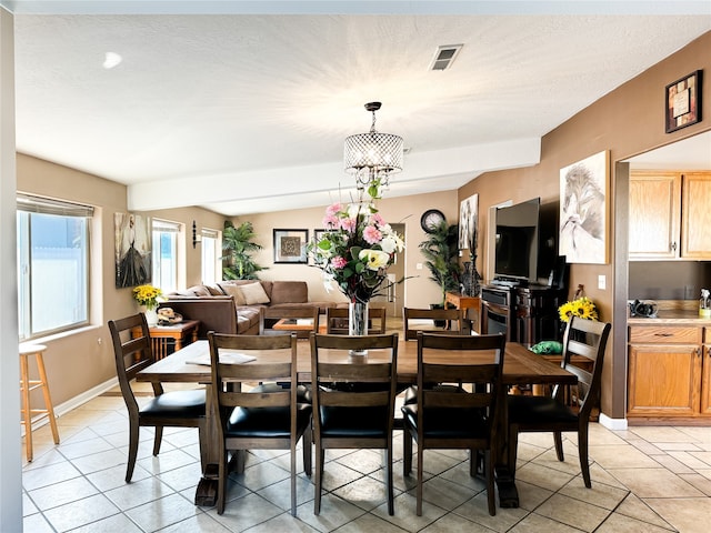 dining room with a notable chandelier, baseboards, visible vents, and light tile patterned floors