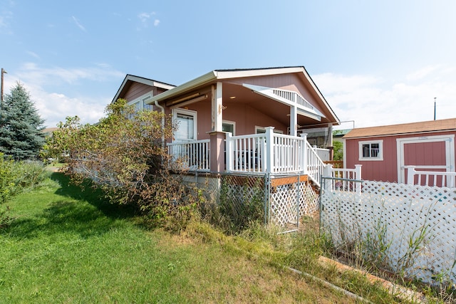 exterior space with a deck, a shed, and a lawn