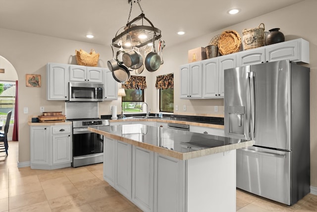 kitchen featuring white cabinetry, sink, stainless steel appliances, and light tile patterned floors