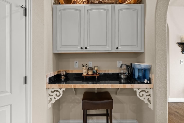 kitchen with white cabinets, a kitchen breakfast bar, and hardwood / wood-style floors